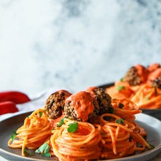 These eggplant meatballs are complemented with a roasted red pepper tahini sauce, served over pasta. Made with eggplants, walnuts, and parsley, these vegan meatballs are gluten-free with an oil-free option.