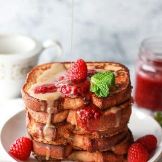 This vegan French toast is made with coconut milk, topped with a raspberry chia jam and coconut creme anglaise. This vegan raspberries and cream French toast has an eggy flavor and stays crispy due to chickpea flour.