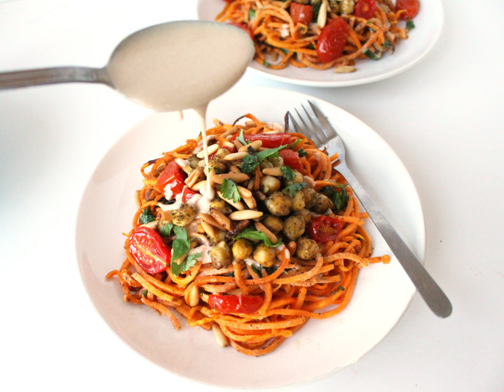 These Mediterranean sweet potato noodles are a vegan, gluten-free dish topped with zaatar roasted chickpeas, burst tomatoes, and a creamy tahini sauce. This plant based recipe makes a healthy, simple meal.