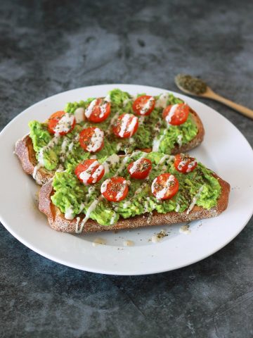 This zaatar avocado toast is a Mediterranean twist on your classic avocado toast, dressed with juicy cherry tomatoes and a creamy 3-ingredient tahini drizzle. This vegan recipe is a modern twist on the classic Middle Eastern breakfast staple of bread with zaatar and olive oil.