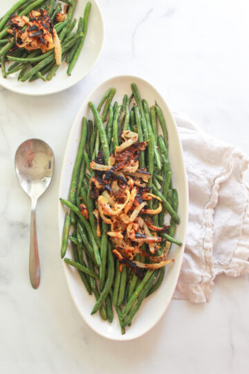 These oven roasted lemon garlic green beans topped with chickpea fried onions make a delicious vegan Thanksgiving side dish.