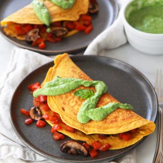 This chickpea omelet recipe is a delicious vegan alternative to a traditional egg omelet. Also gluten-free, this chickpea omelet does not crack or break when flipped, can be stuffed with your favorite veggies, and is topped with a dairy-free avocado pesto.