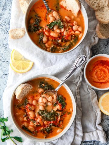 This Mediterranean white bean soup is flavored with Harissa and tahini. Filled with kale, parsley, and thyme, this vegan white bean soup is hearty, flavorful, and creamy.