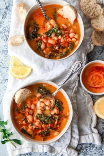 This Mediterranean white bean soup is flavored with Harissa and tahini. Filled with kale, parsley, and thyme, this vegan white bean soup is hearty, flavorful, and creamy.