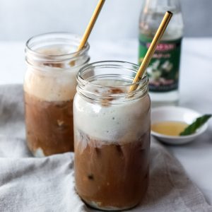 Foamy Iced Oat Milk Latte with Orange Blossom Water, Vegan, topped with cinnamon.