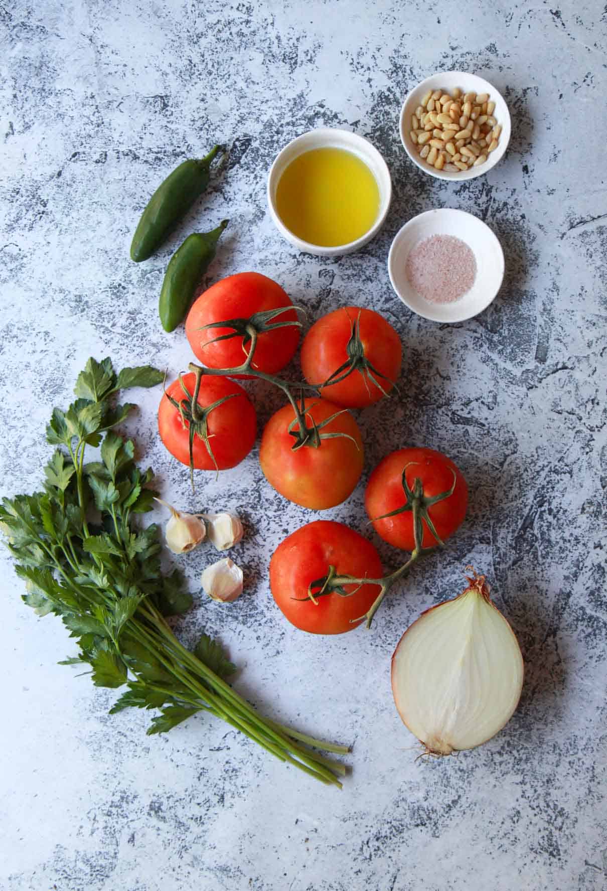 This shows the galayet bandora ingredients: tomatoes, onion, parsley, garlic, olive oil, salt, jalapeño, and pine nuts.