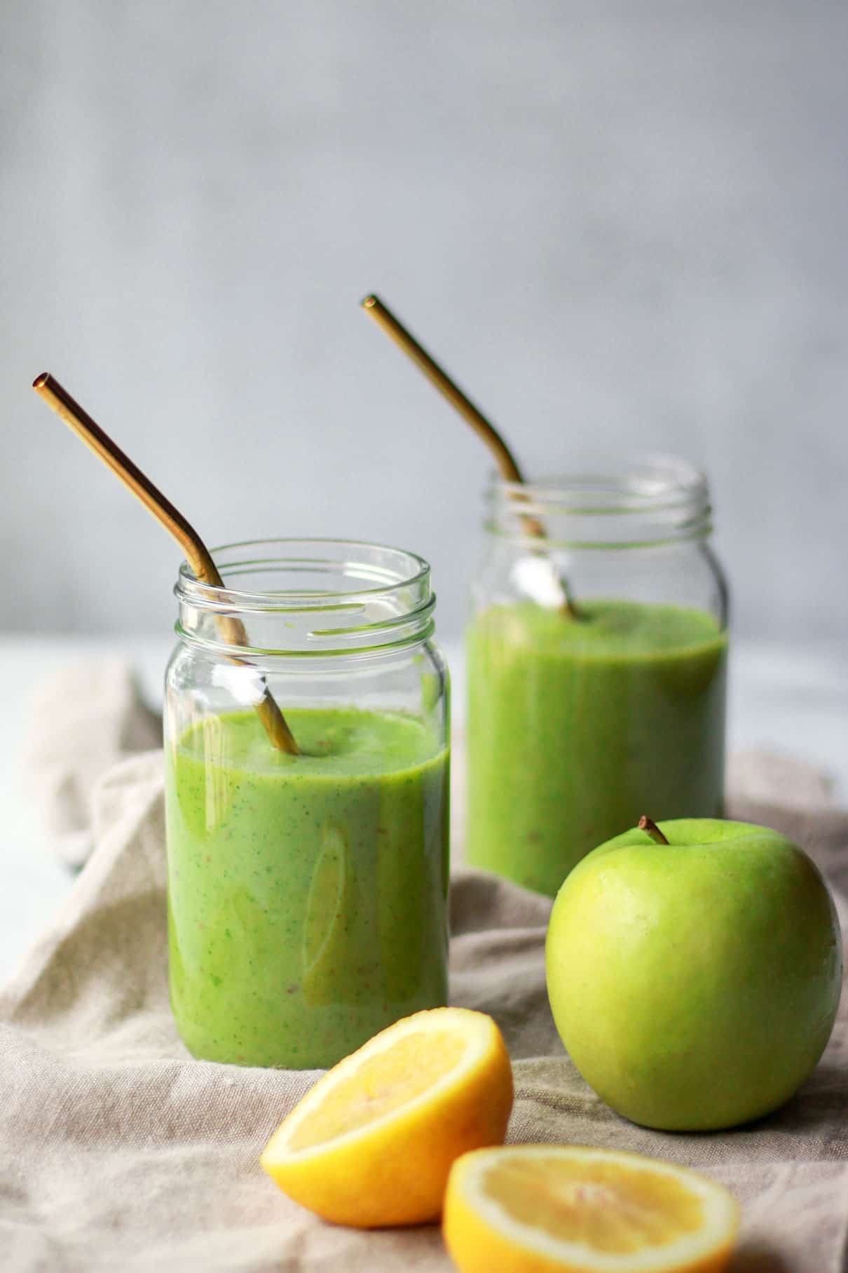 Two jars of green apple smoothie with lemon and green apple