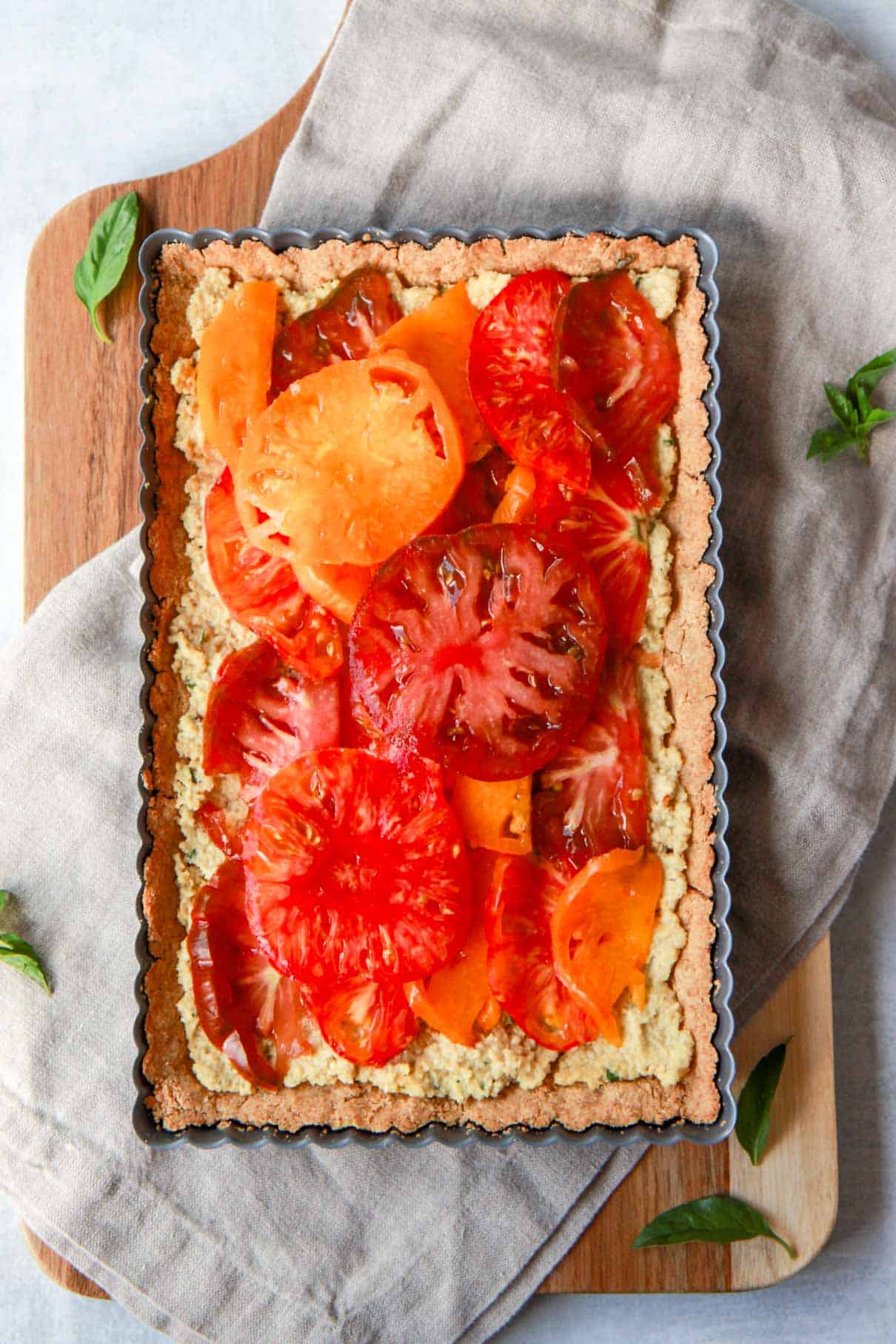 Placing the sliced heirloom tomatoes on top of the cashew ricotta