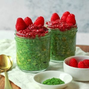 Image featuring a straight on shot of the overnight matcha oats topped with raspberry chia jam cropped square