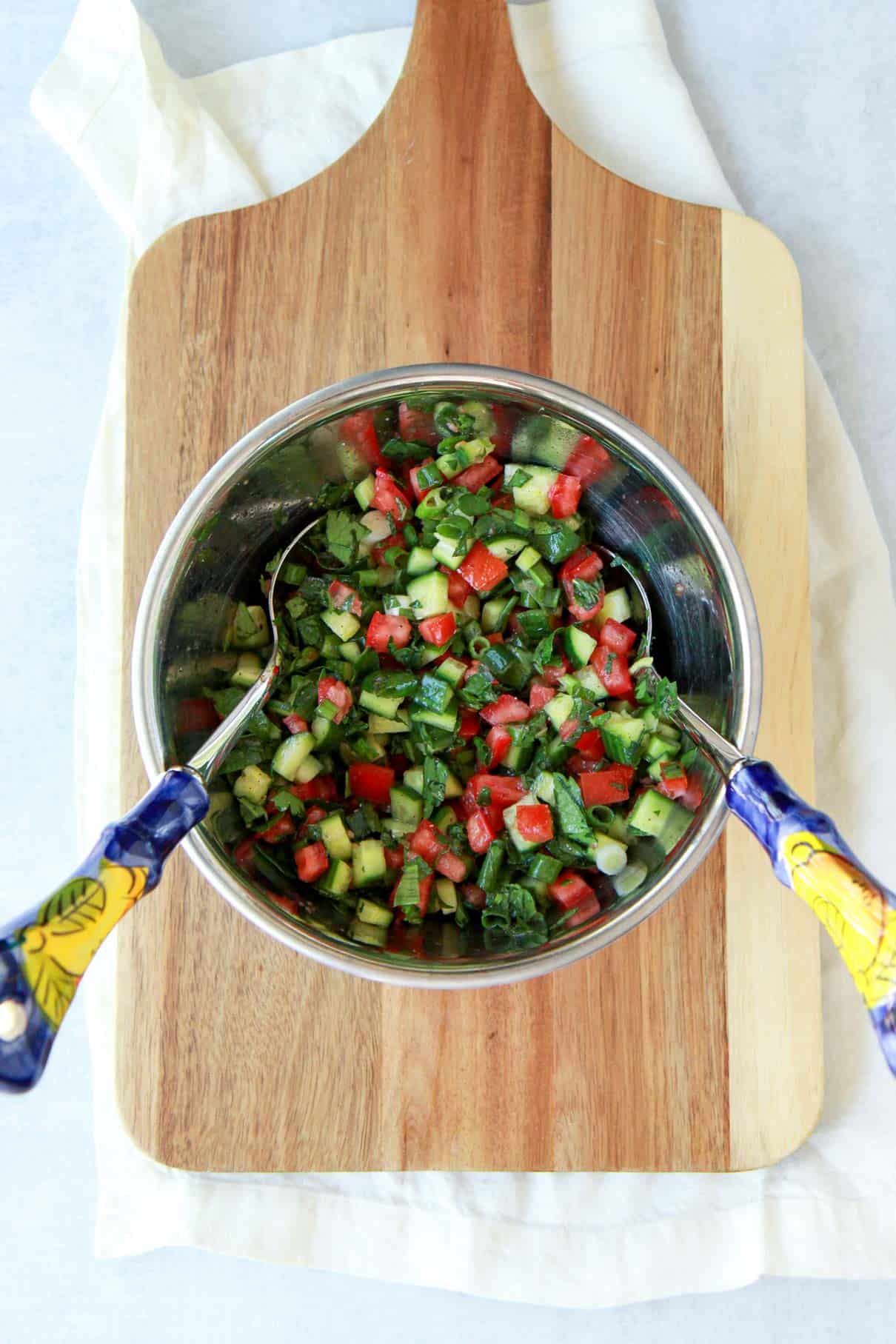 This shows how to mix the Mediterranean chopped salad to combine.