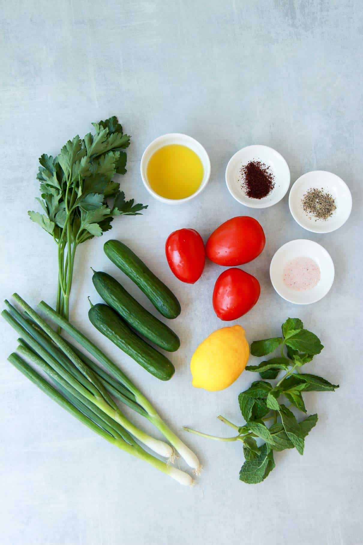 This shows the ingredients to make Palestinian salad: fresh veggies and herbs.