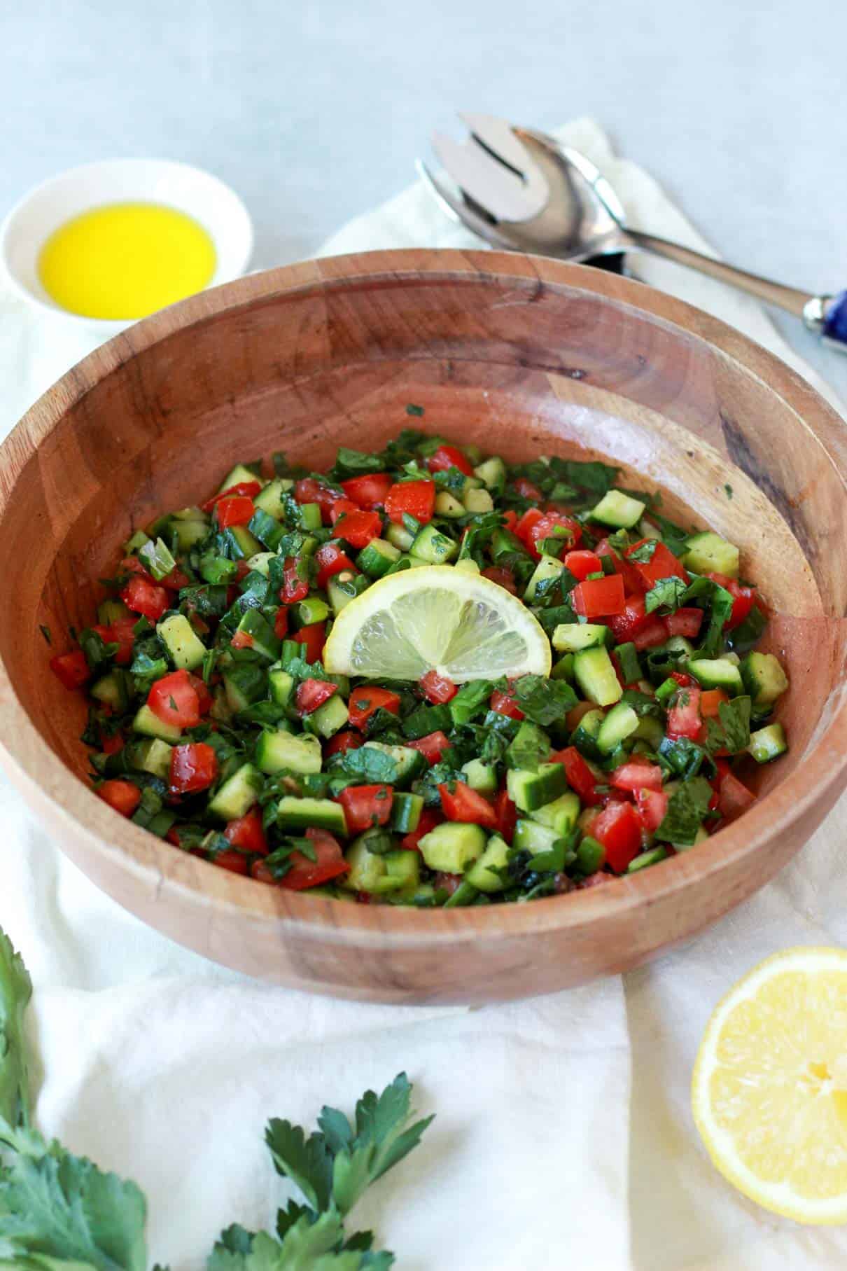 The salad is being garnished with a fresh lemon slice in this photo.