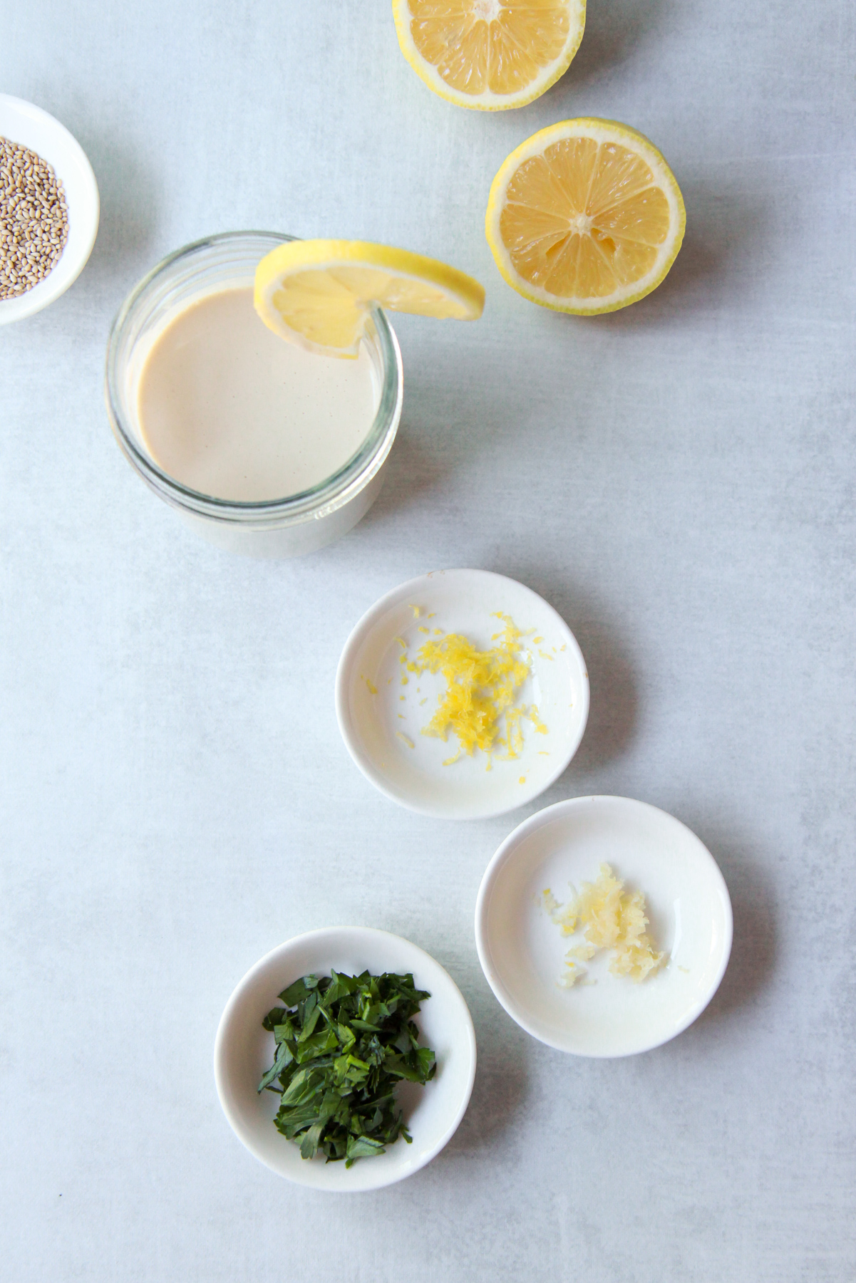 Tahini sauce accompanied by optional mix-ins including parsley, lemon zest, and garlic.