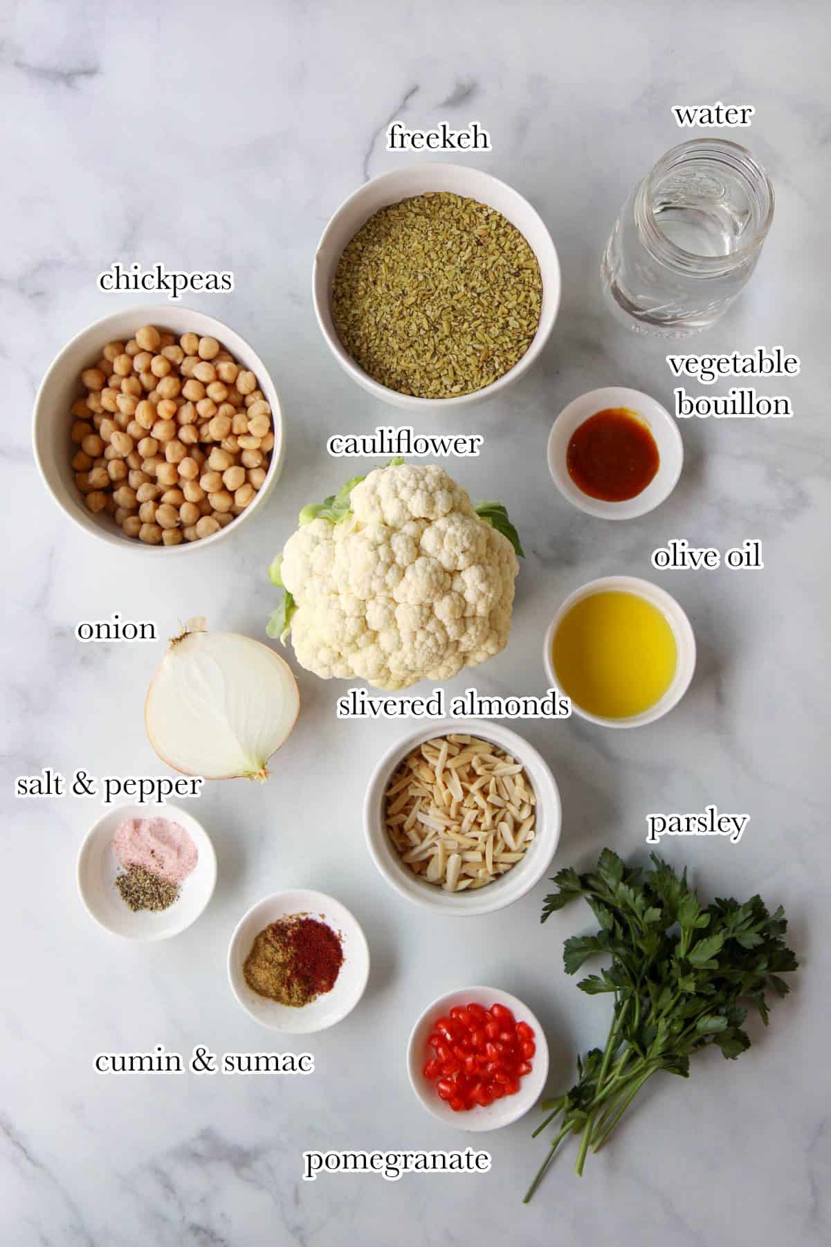 This shows all the ingredients needed for the vegan freekeh recipe, including cauliflower, chickpeas, spices, olive oil, freekeh, and more.