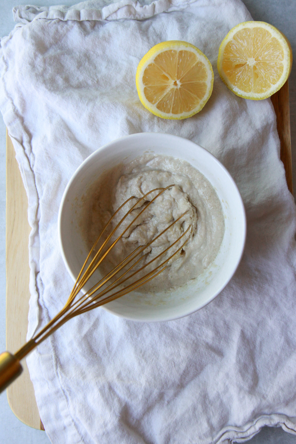 Whisking lemon and tahini to form a thick paste.