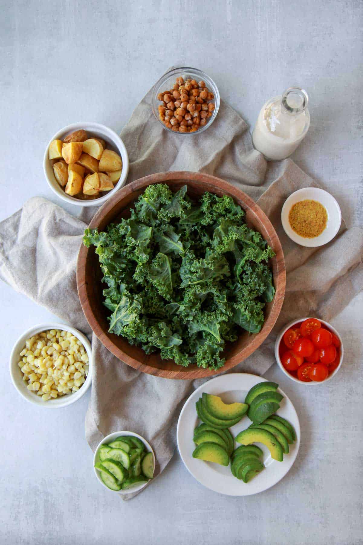 All the ingredients needed for the hearty kale salad with chickpeas, including the tahini dressing.