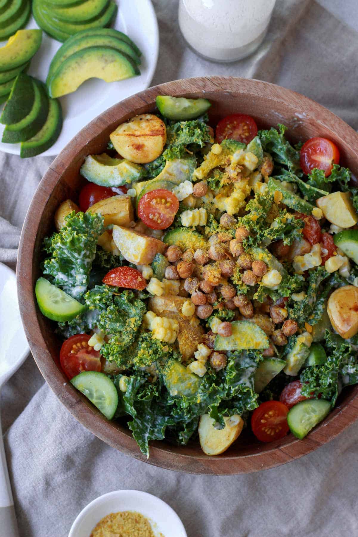 The kale salad after being mixed with the ingredients and tahini dressing, topped with extra chickpeas and nutritional yeast.