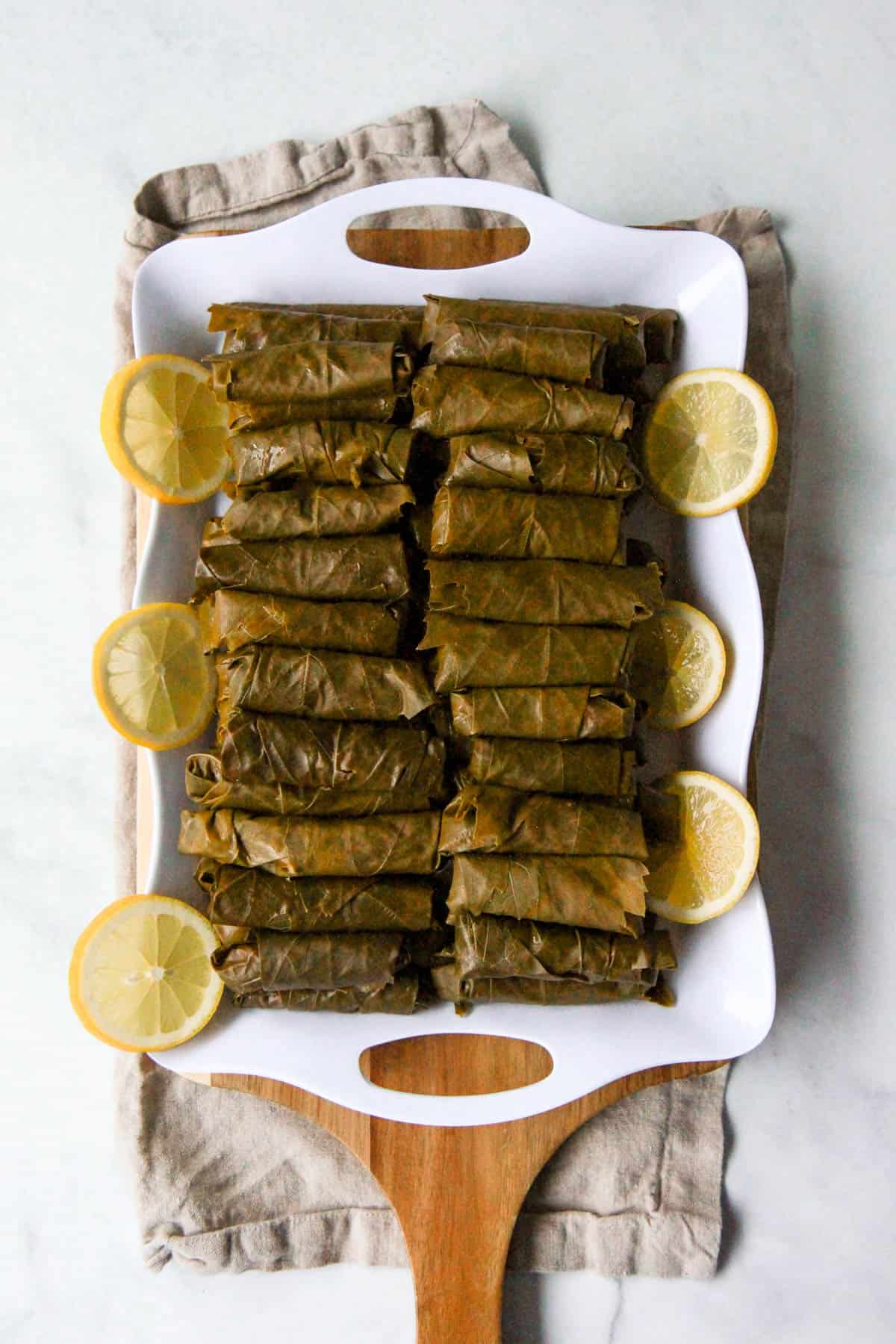 A tray of uncooked, rolled yalanji, before placing and cooking in the pot.