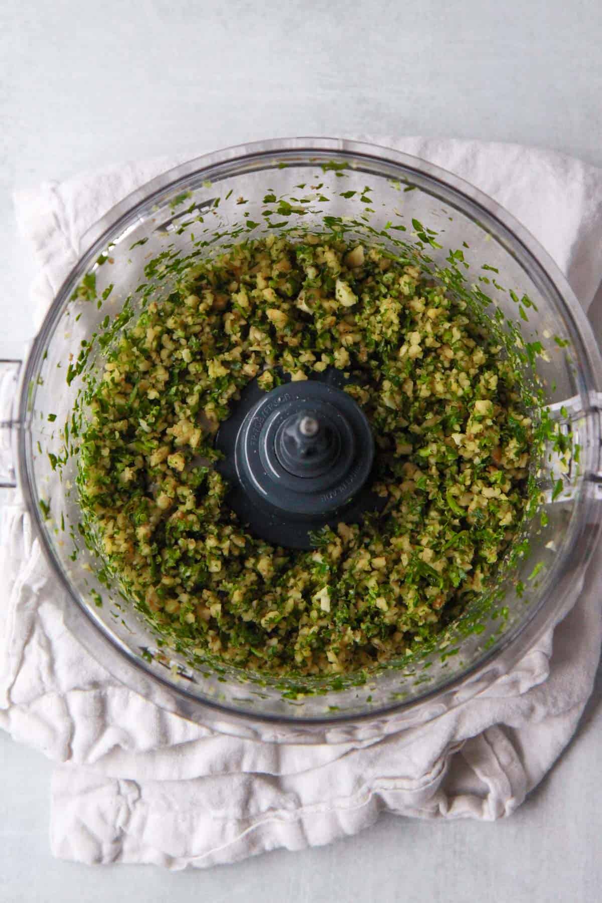 The walnuts, parsley, and garlic are shown after pulsing until crumbly in the food processor.