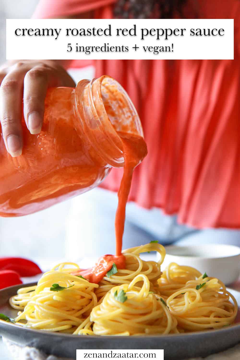 The roasted red pepper sauce is poured over pasta with text overlay, "creamy roasted red pepper sauce - 5 ingredients + vegan!".