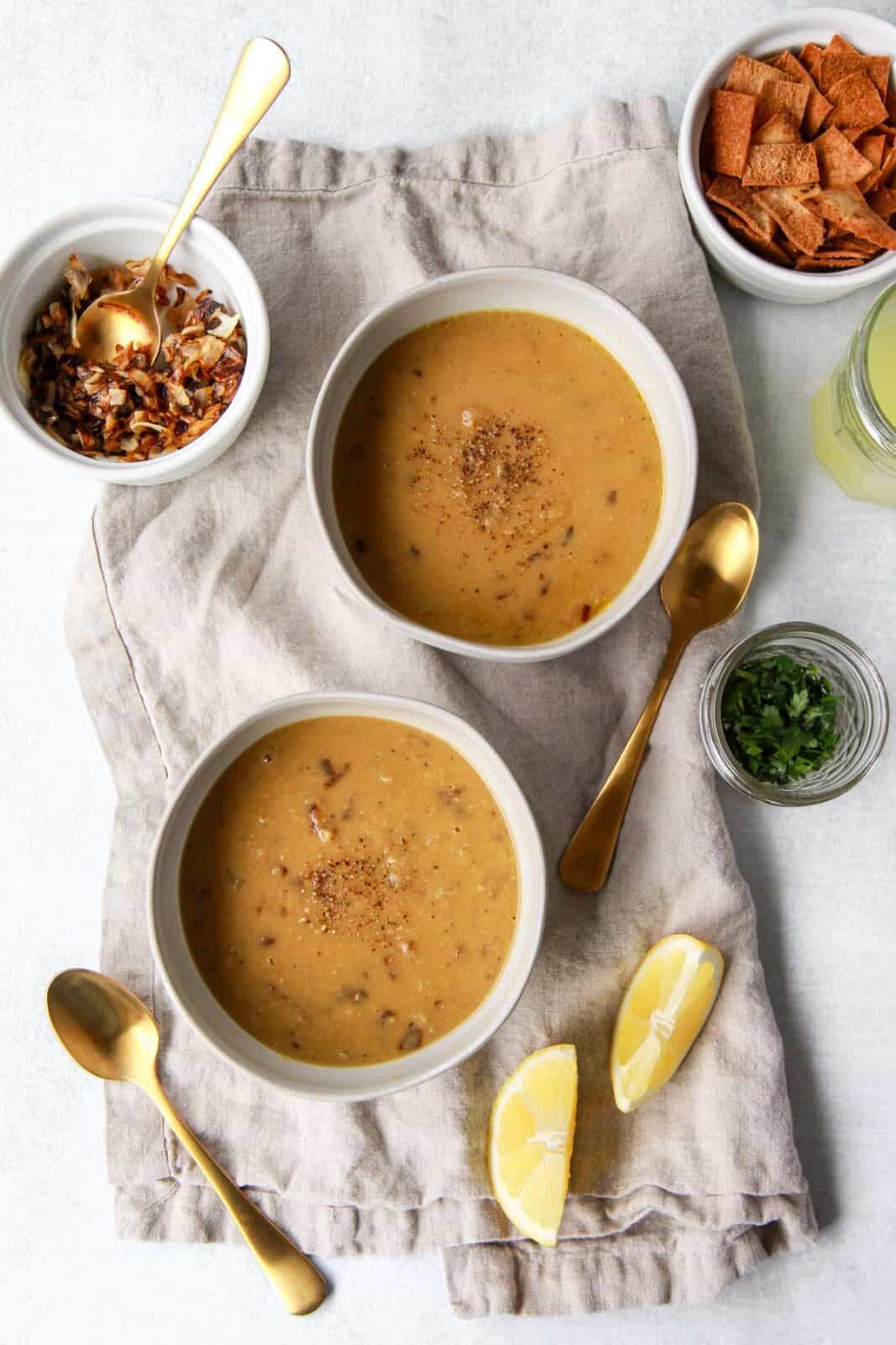 Two bowls of Arabic lentil soup before adding toppings.