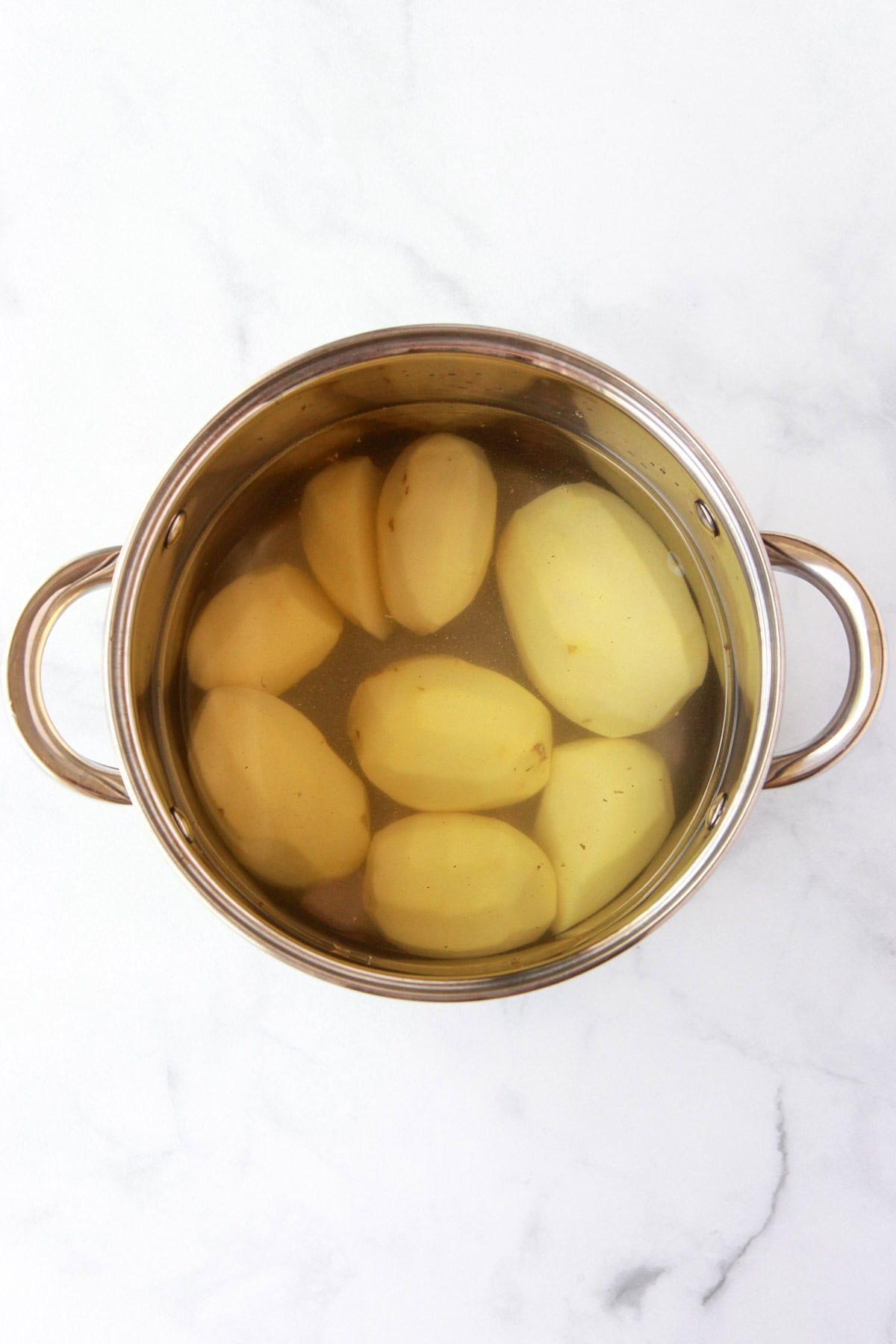 Boiling peeled potatoes.