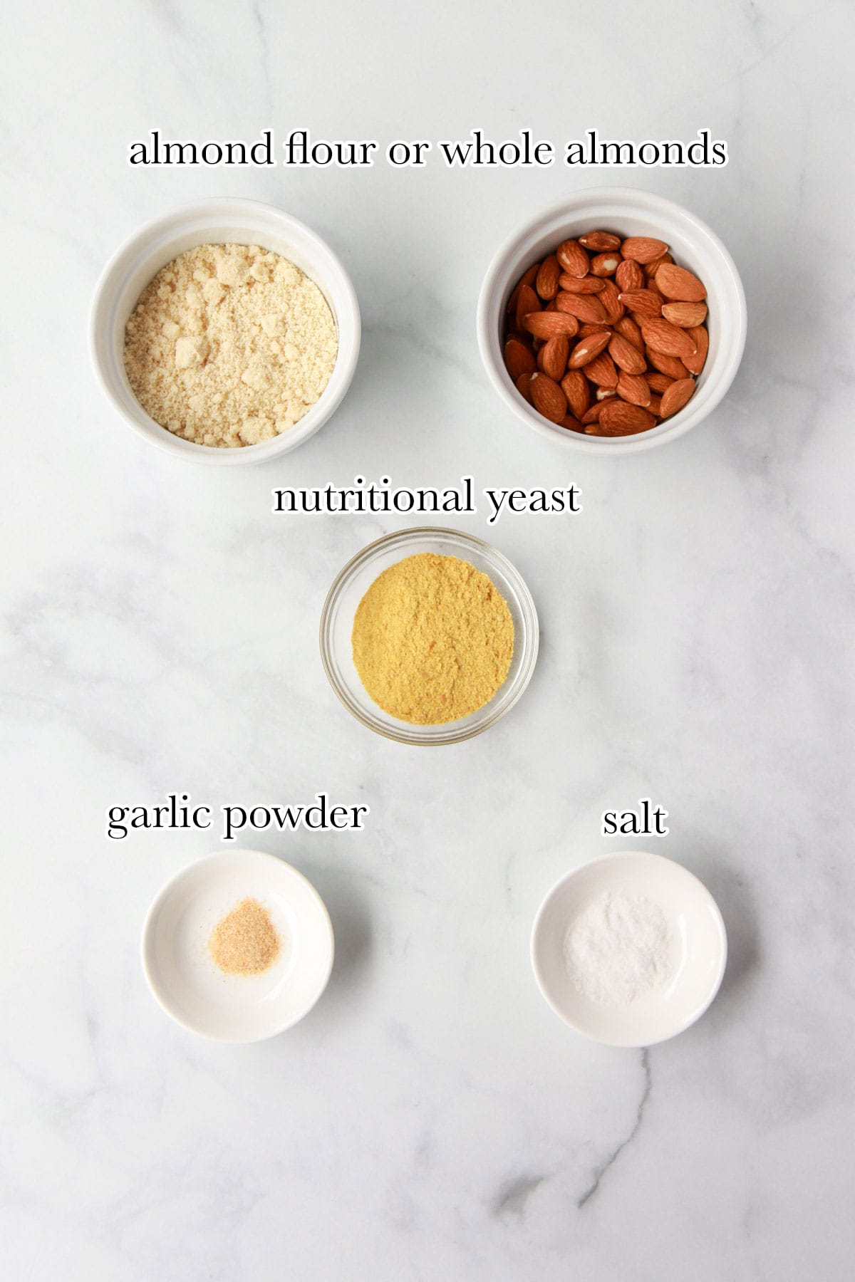 Almond parmesan ingredients including almond flour, whole almonds, nutritional yeast, garlic powder, and salt.
