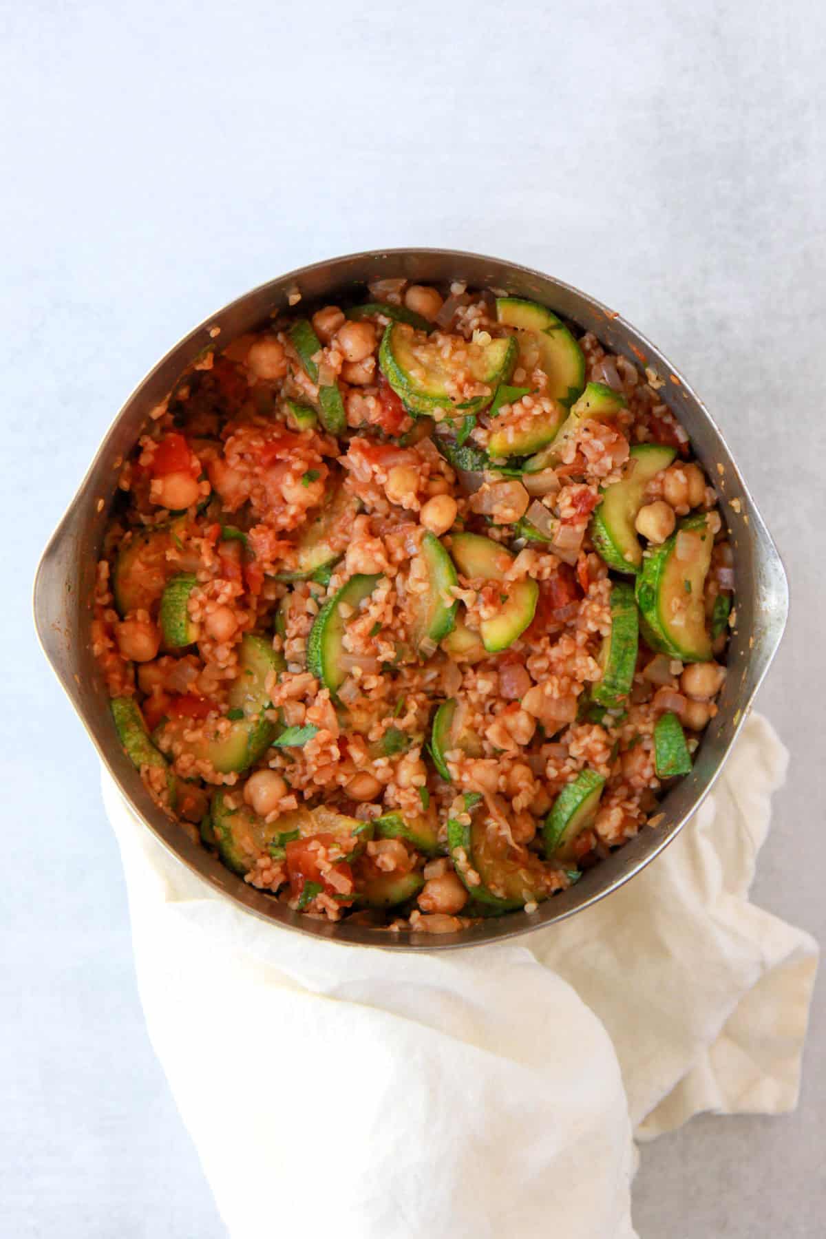 The pot of bulgur pilaf after mixing in the squash and parsley.