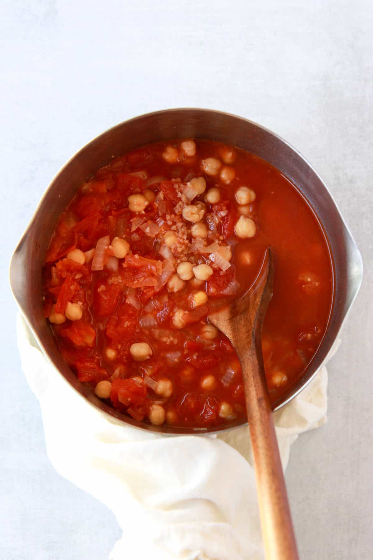 This image shows simmering the bulgur and chickpeas in the tomato broth.