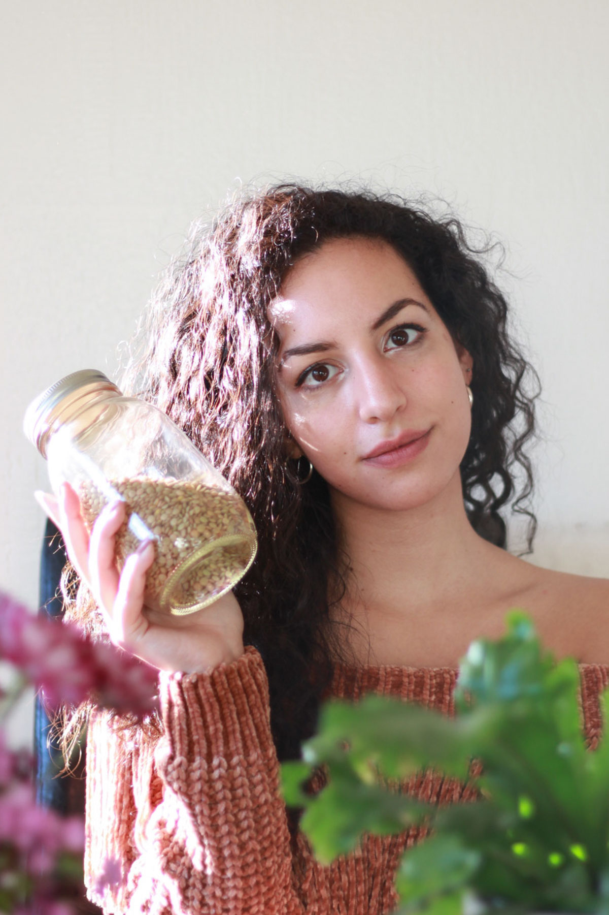 An image of Zena holding lentils stored in a sealed jar.