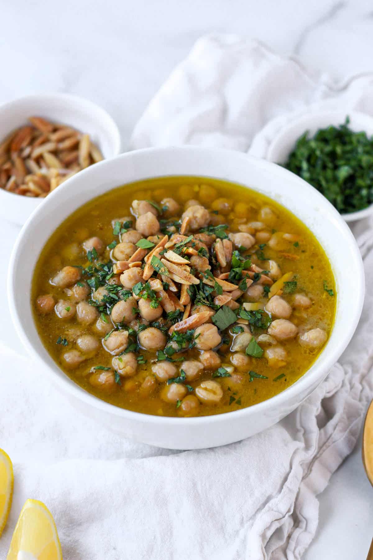 Finished balila in a bowl topped with fresh parsley and slivered almonds.
